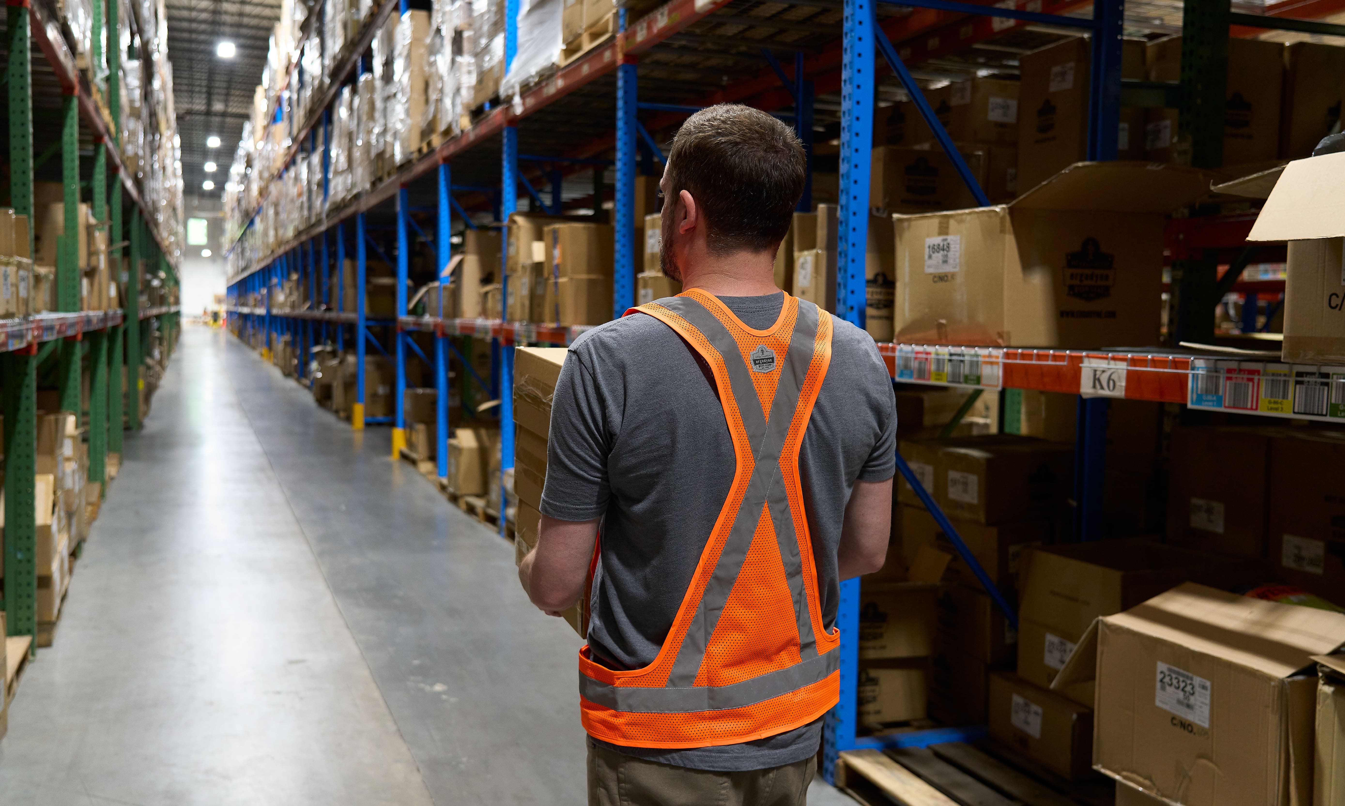 Worker wearing x-back safety vest while in warehouse