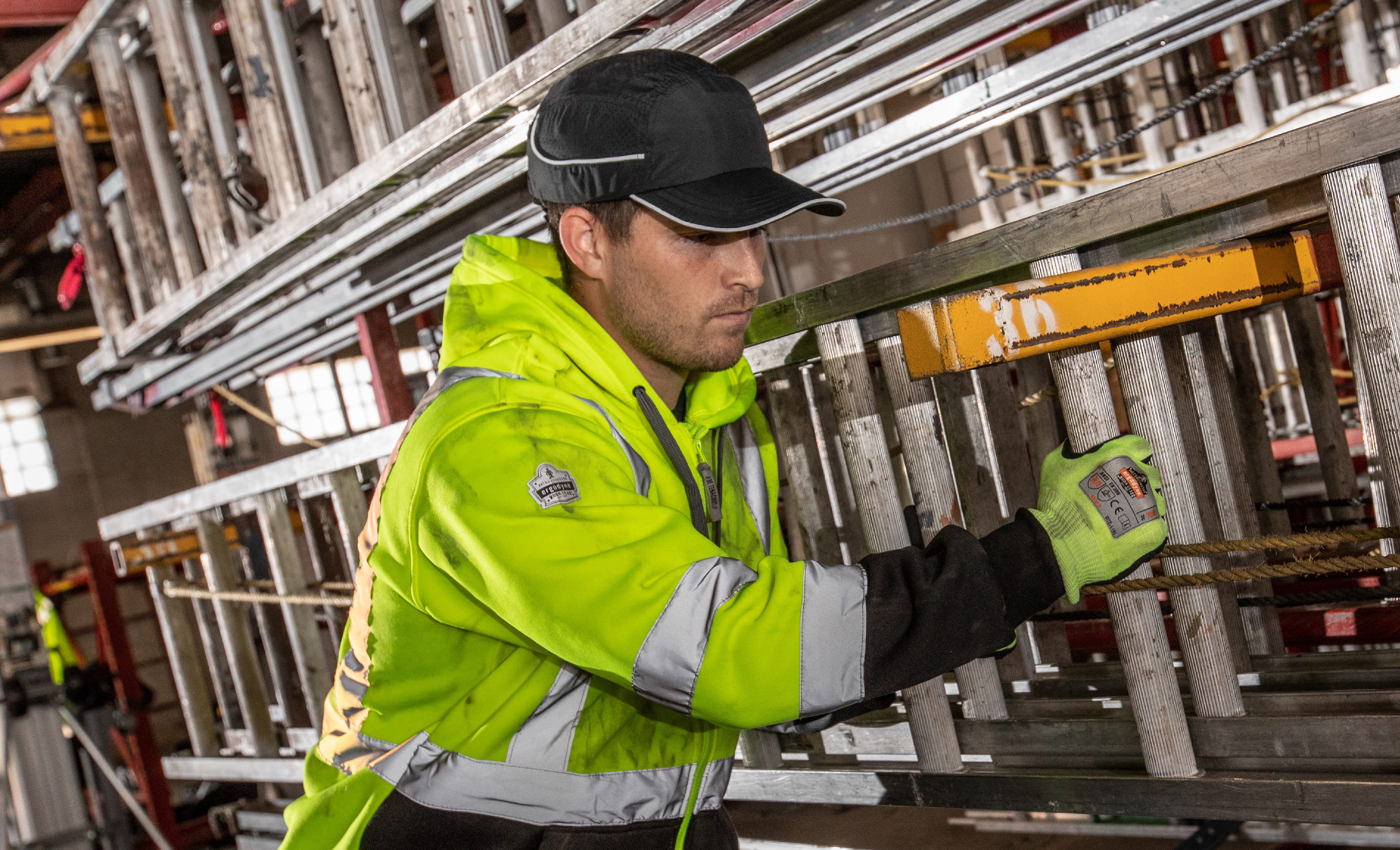 Worker wearing a bump cap hat while moving ladders