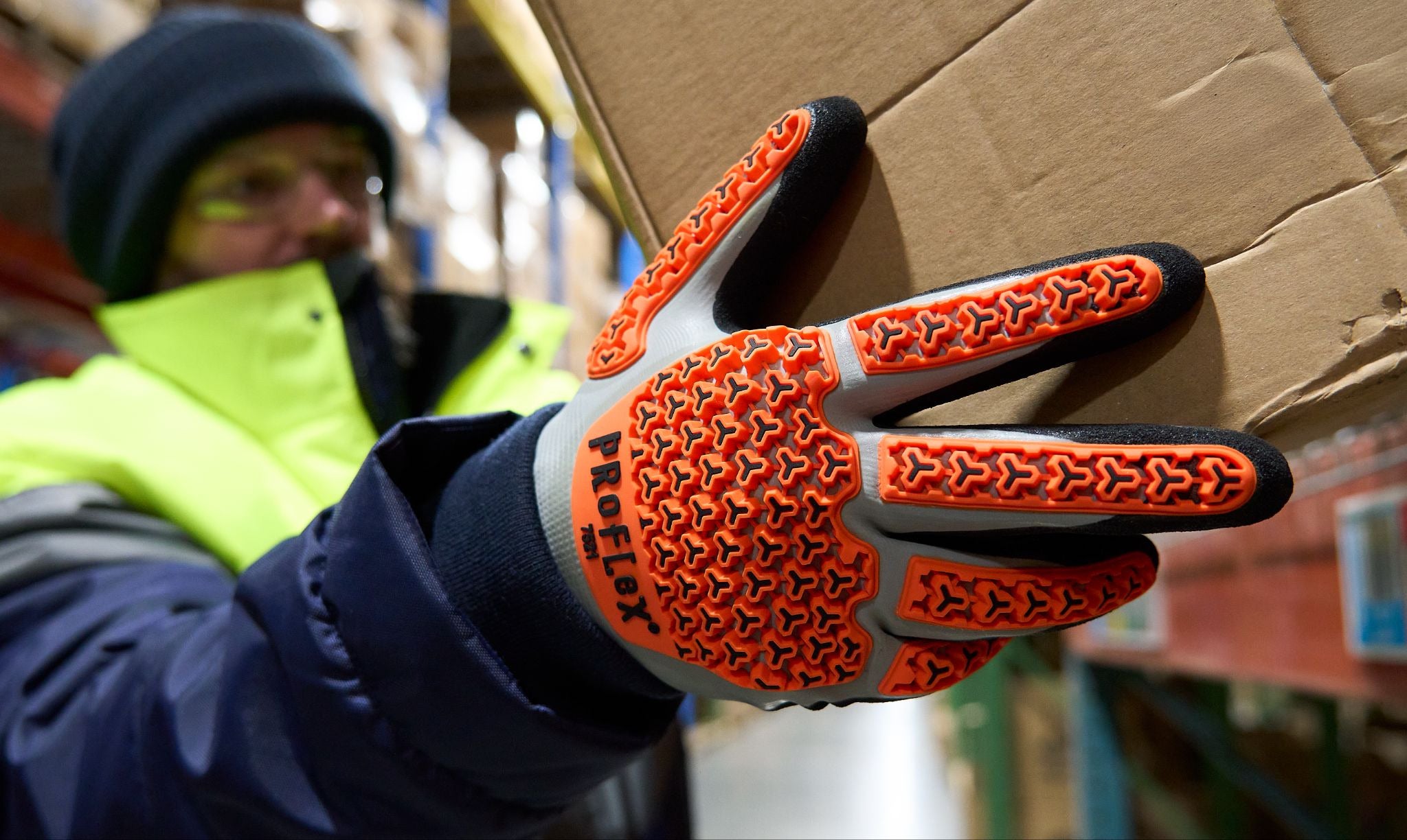 Worker holding up box while wearing thermal coated impact glove