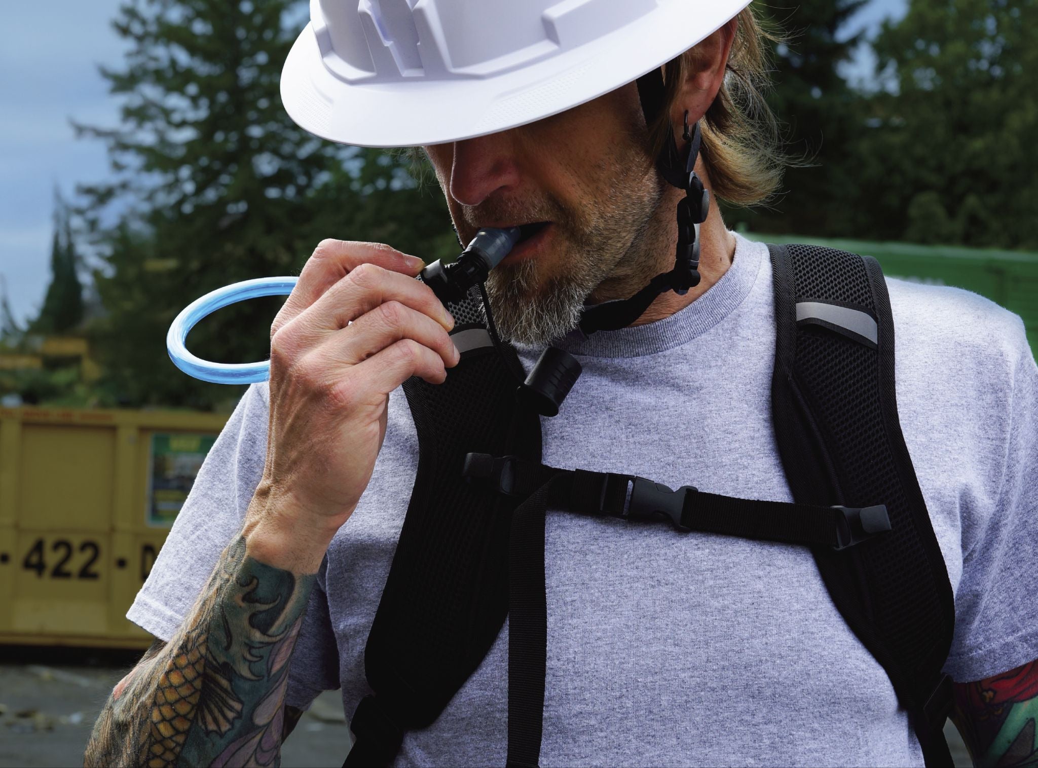 Worker drinking from a hydration pack