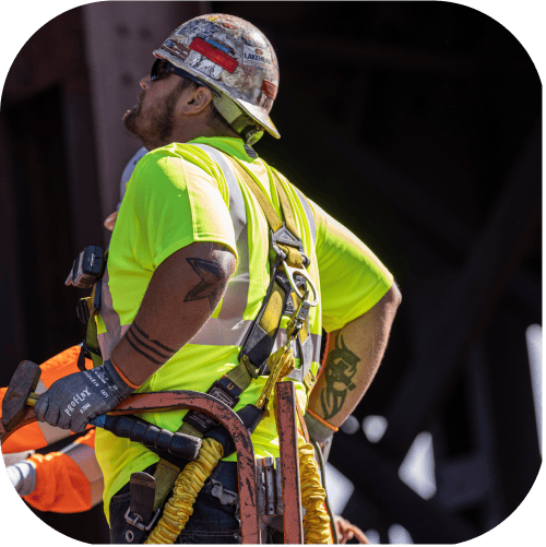 Worker looking up from atop a MEWP, wearing a GloWear 8289-ECO shirt made from recycled materials