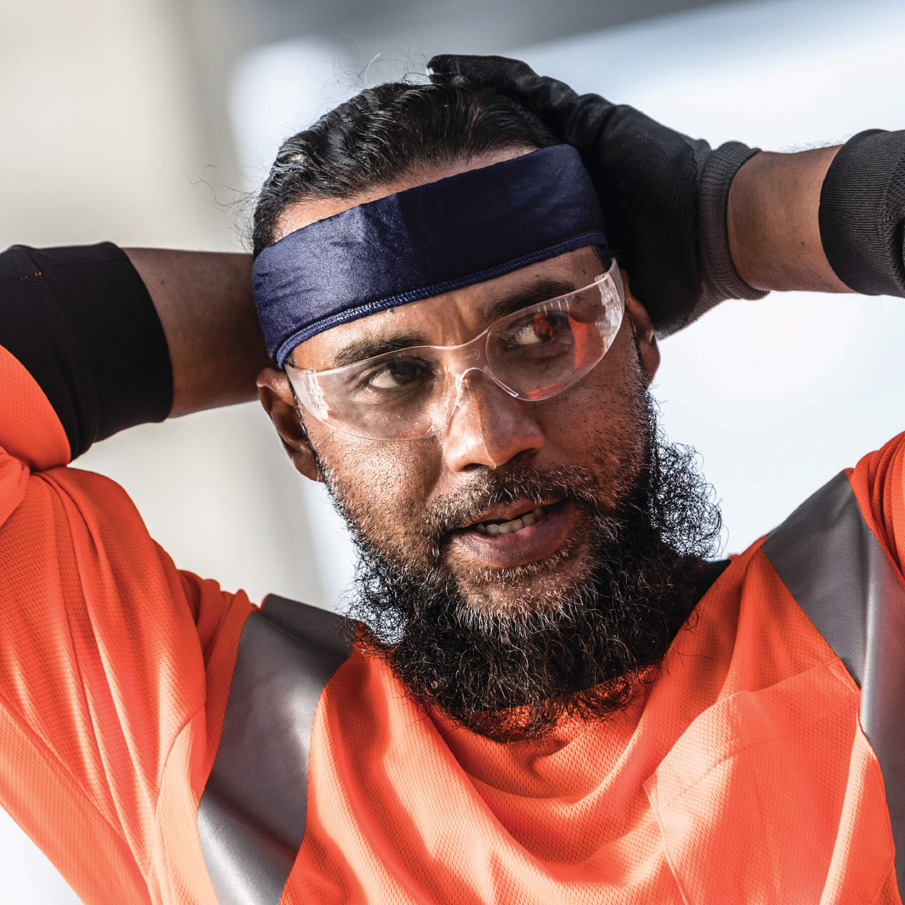 Worker in cooling bandana with embedded polymers