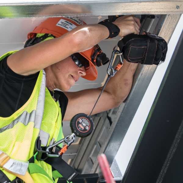 Construction worker using tethered power drill while working at-heights