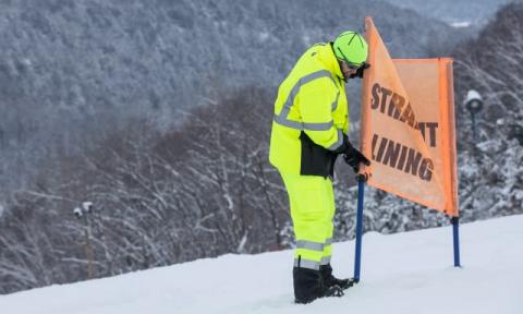 Fixing a sign in frigid conditions, in hi vis gear