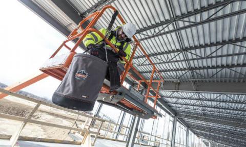 Worker at height on a boom lift, working with a tethered tool bucket