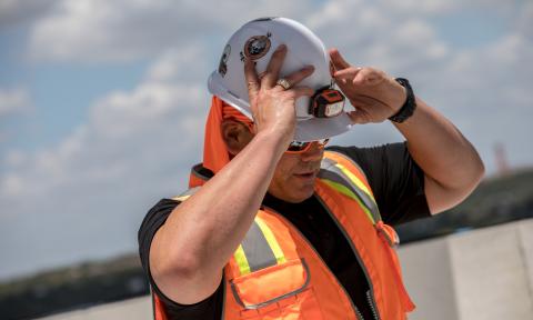 Worker putting on hard hat