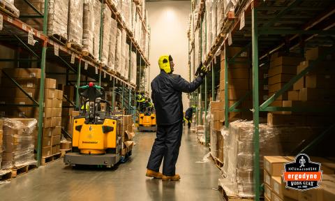 Worker staring up at inventory racks in freezer warehouse