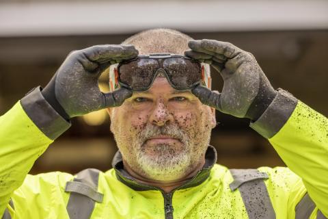 man wearing safety goggles with dirt on face