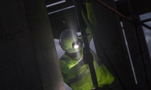 Worker in hi-vis vest wearing a headlamp in a dark area