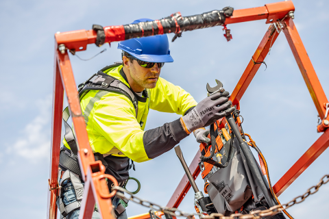 Worker at heights using a tool that is tethered