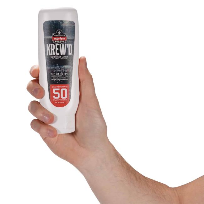 hand holding bottle of sunscreen