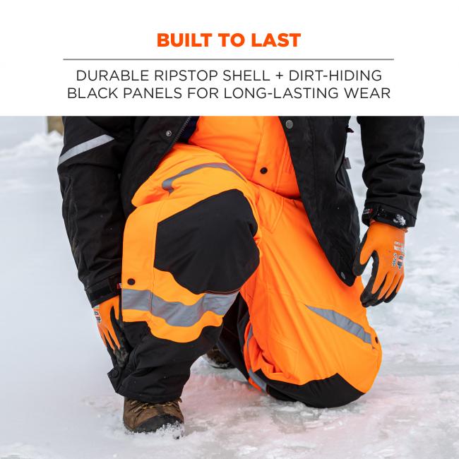 Built to last: durable ripstop shell + dirt-hiding black panels on front for long-lasting wear. Image is person kneeling in the snow wearing bibs. 