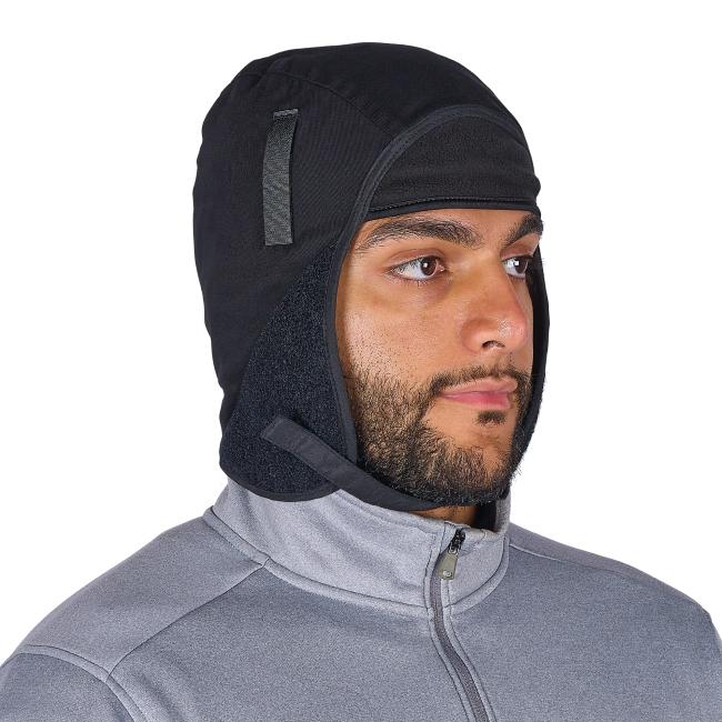 Close-up of a bearded person wearing a black fleece-lined hood and gray zip-up jacket, showing eyes, nose, and mouth.