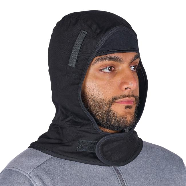 Close-up of a man's face and eyes wearing a black hood with padded neck flap and Velcro tab over a gray top