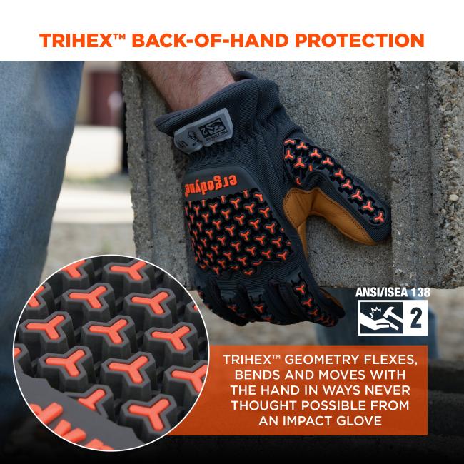 Black protective work glove with orange Y-shaped raised rubber pads and brown leather palm, shown against a rough concrete surface