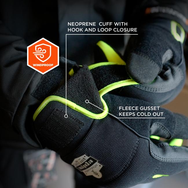 Close-up of black winter gloves with neon yellow trim, Velcro cuff, fleece lining, and orange windproof badge