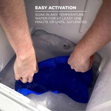 Easy activation: soak in any temperature water for at least one minute or until saturated. Image shows person submersing towel into cooler of water