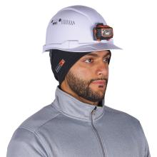 White safety hard hat with orange-and-black mounted headlamp worn by a man wearing a black head liner and gray zippered jacket.