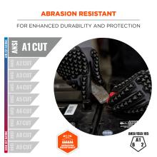 Close-up of textured black-gray gloves with red accents gripping a tool on a battery; packaging text 'ABRASION RESISTANT' and 'A1 CUT'.
