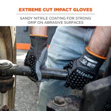 Close-up of two hands in gray textured gloves with orange trim gripping a rusted metal pipe, person wearing jeans