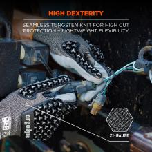 Close-up of gray knit work gloves with black textured grip pads holding electrical wires and connectors, with orange "HIGH DEXTERITY" text.