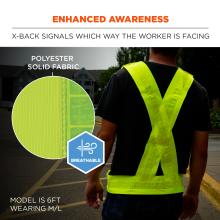 Rear view of person wearing neon yellow X-back reflective safety vest over dark shirt, fabric close-up circle and "breathable" badge visible