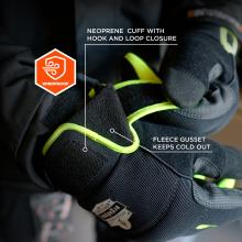 Close-up of black winter gloves with neon yellow trim, Velcro cuff, fleece lining, and orange windproof badge