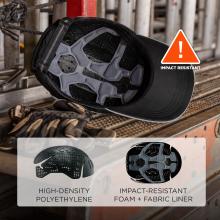 Black cap interior with grey padded impact foam liner on a metal workbench, worn gloves beside, orange triangle reading "IMPACT RESISTANT"