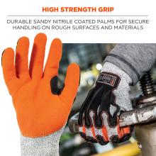 Close-up of two work gloves: orange sandy-coated glove palm and gray knit glove with black and orange reinforcements gripping a metal pipe.