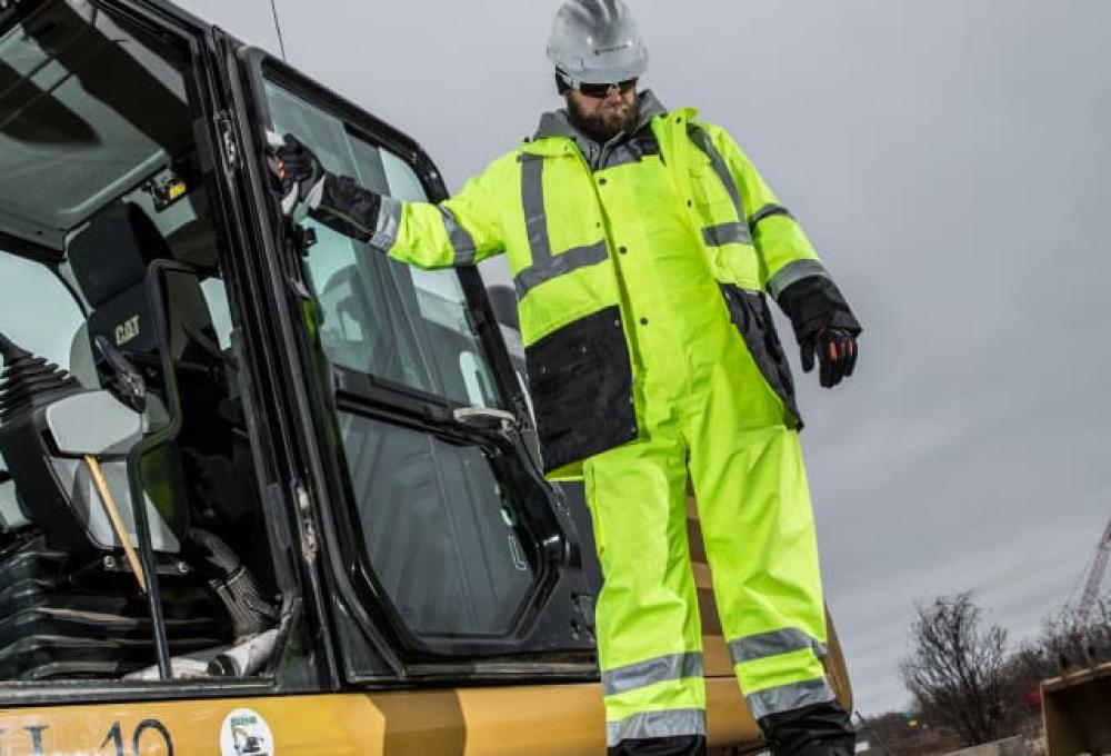 Hi vis waterproof gear, standing on large vehicle