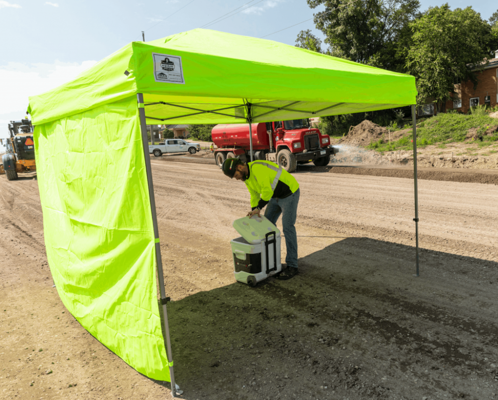 Worker protected from sun in a tend with a sidewall