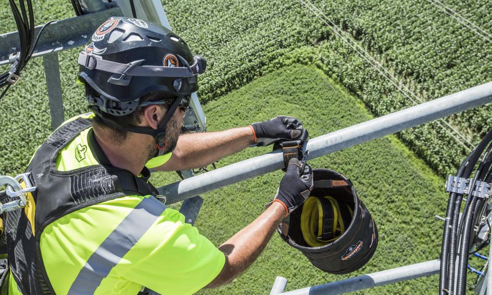 Worker attaching hoist bucket to structure