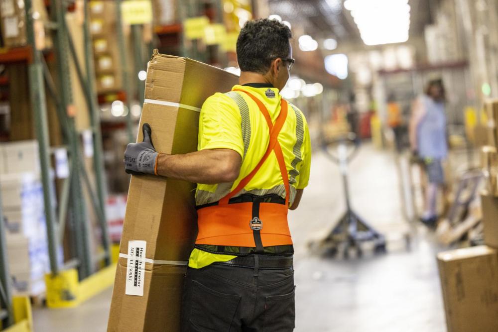 man wearing back support and gloves lifting a box