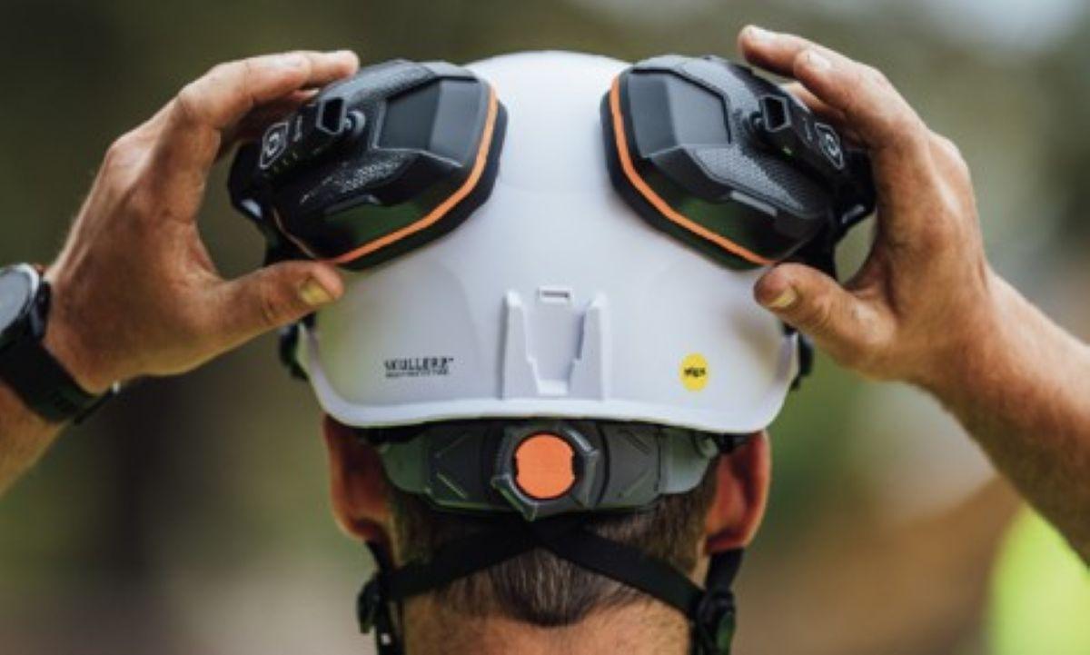 Worker wearing a safety helmet with hearing protection