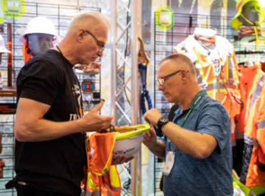 About Us | Our Commitment | Two workers examining hard hat