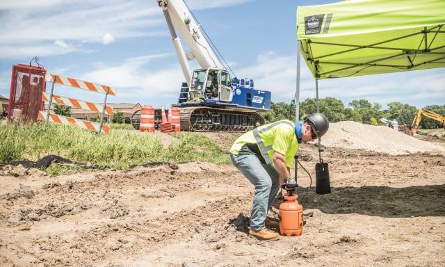 Construction worker setting up a tent for shade