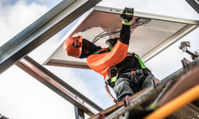 Telecom worker installing solar panels