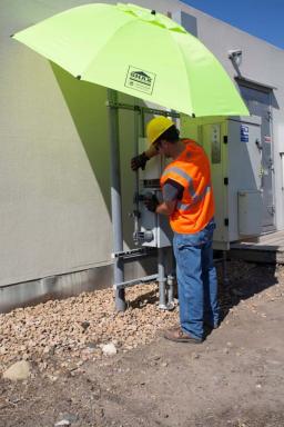 Laborer working on project, covered from sun by an umbrella shade